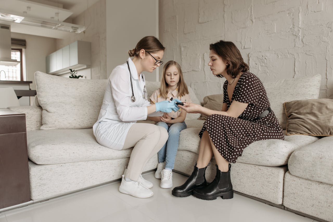 Services A medical professional examines a childs hand while the mother watches closely.
